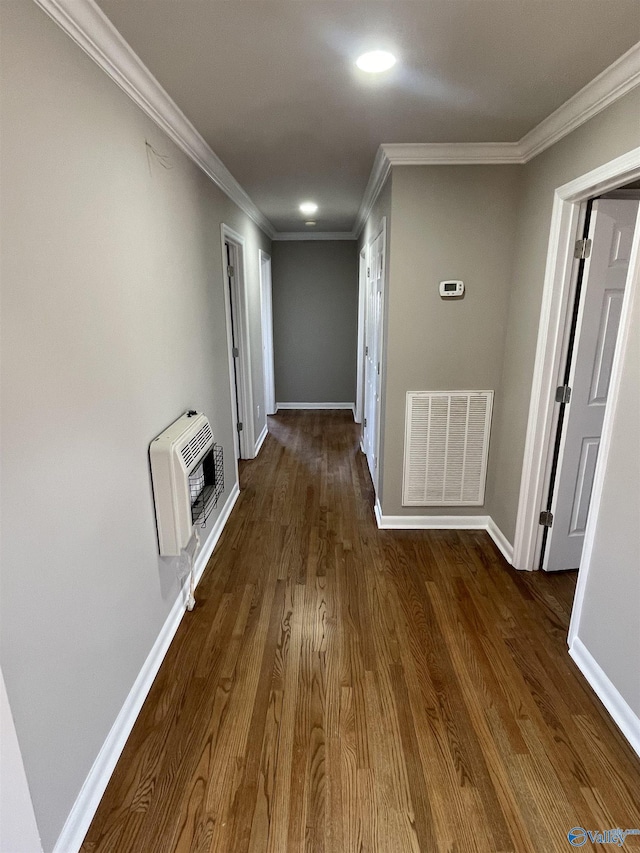 hall featuring heating unit, baseboards, visible vents, dark wood finished floors, and ornamental molding