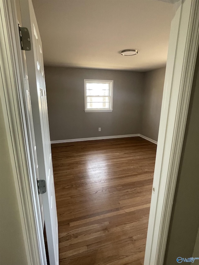 empty room featuring baseboards and wood finished floors