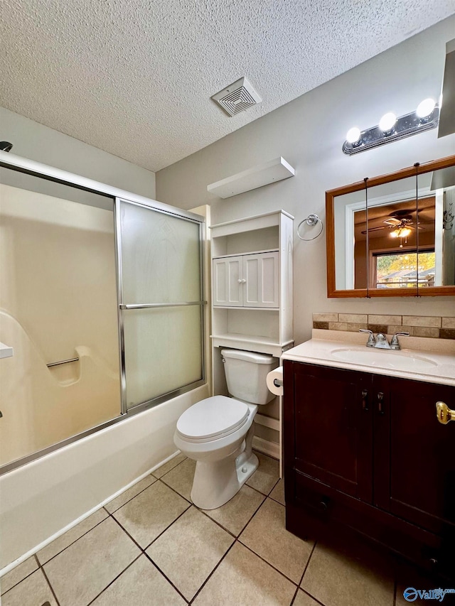 full bathroom featuring visible vents, toilet, tile patterned flooring, a textured ceiling, and vanity