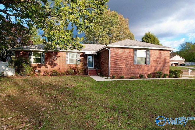 single story home featuring a front yard and brick siding