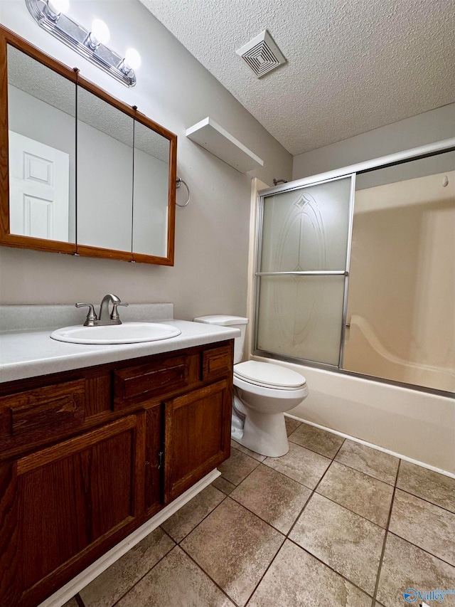 bathroom featuring a textured ceiling, toilet, vanity, and visible vents