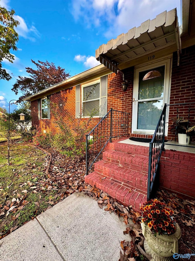 property entrance featuring brick siding