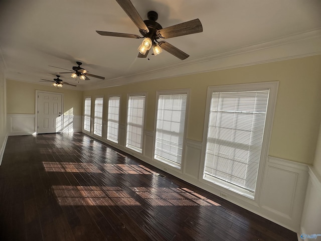 unfurnished room featuring a wainscoted wall, ornamental molding, wood-type flooring, and a ceiling fan