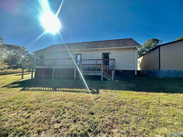 back of property with a deck and a lawn