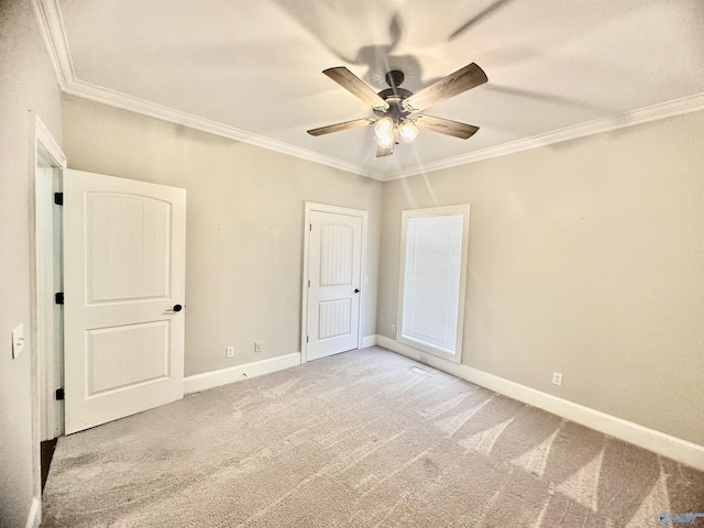 unfurnished bedroom with crown molding, carpet flooring, baseboards, and a ceiling fan
