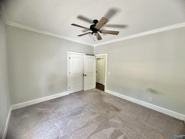 unfurnished bedroom with crown molding, baseboards, ceiling fan, and carpet flooring
