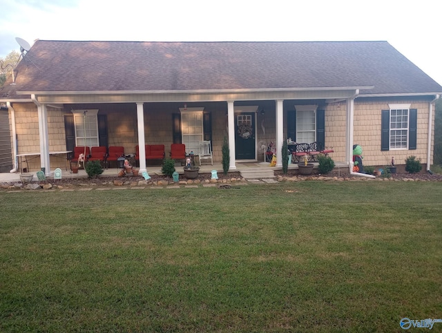 rear view of house with a lawn and roof with shingles