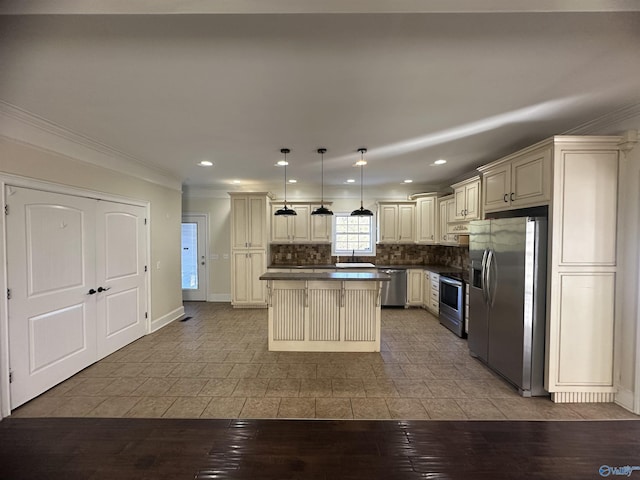 kitchen featuring a center island, ornamental molding, appliances with stainless steel finishes, and cream cabinets