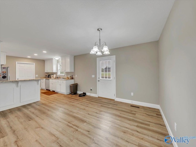 interior space featuring baseboards, light wood-type flooring, dishwasher, white cabinetry, and visible vents