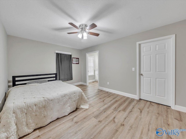 bedroom with a textured ceiling, wood finished floors, and baseboards
