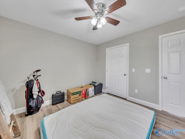 bedroom with baseboards, light wood-type flooring, and ceiling fan