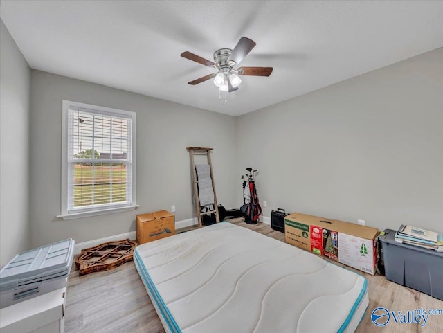 bedroom featuring ceiling fan, baseboards, and light wood-type flooring