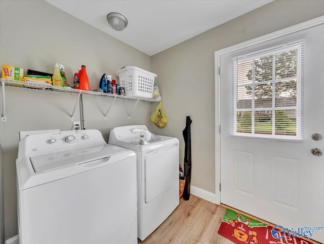 laundry area featuring a healthy amount of sunlight, independent washer and dryer, laundry area, and light wood-style floors