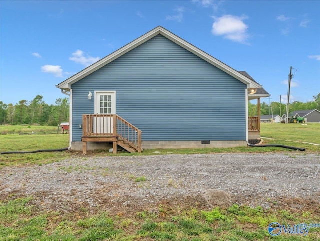 view of side of home featuring a yard and crawl space