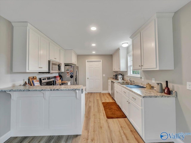 kitchen featuring white cabinetry, light wood-style floors, and appliances with stainless steel finishes