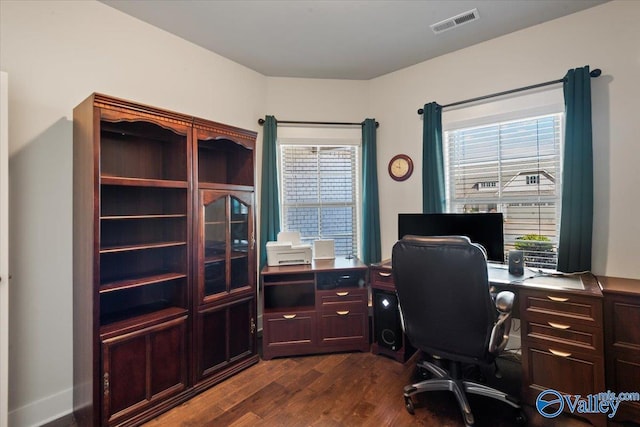 office with dark wood-type flooring and visible vents