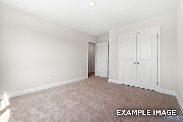 unfurnished bedroom with light carpet and a closet