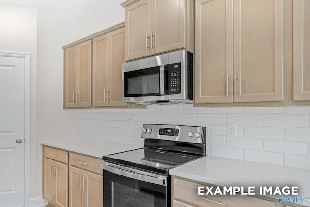 kitchen with appliances with stainless steel finishes, light brown cabinets, and backsplash