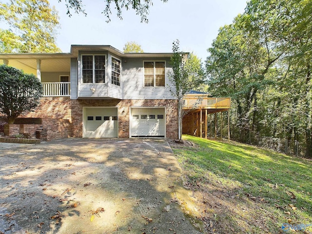 view of front of property featuring a garage, a front lawn, and a deck