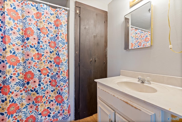 bathroom with curtained shower, vanity, and wood-type flooring