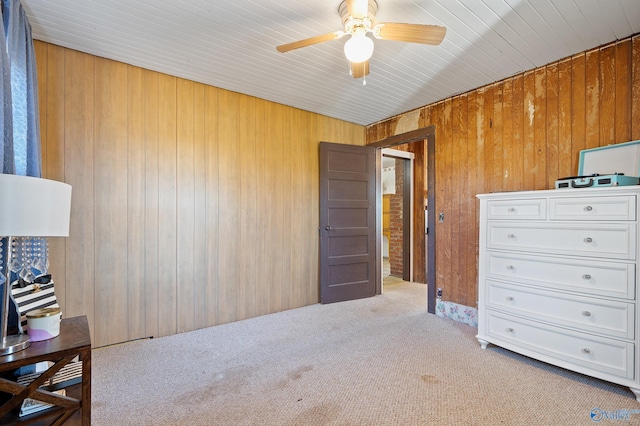 carpeted bedroom with ceiling fan and wooden walls