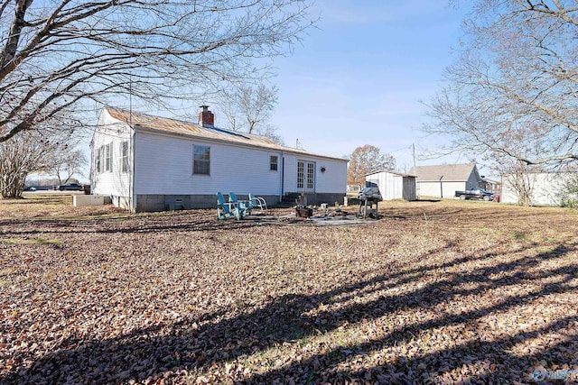 rear view of property with a patio and a storage unit