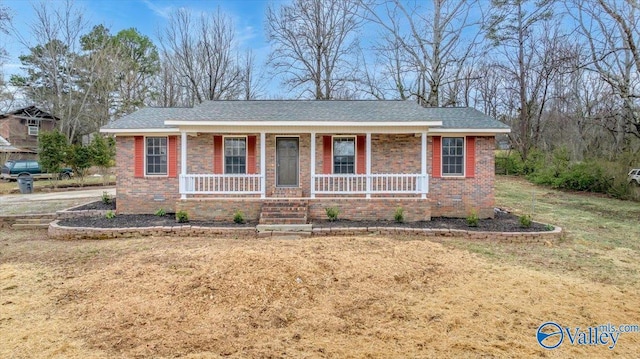 ranch-style home featuring a porch, a front yard, and brick siding