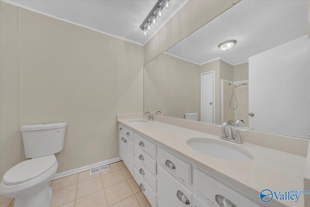 full bathroom with tile patterned floors, a sink, a textured ceiling, and double vanity