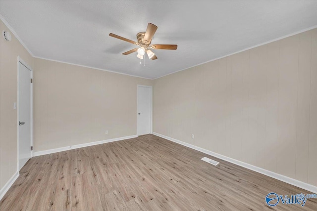unfurnished room featuring light wood finished floors, visible vents, baseboards, a ceiling fan, and crown molding