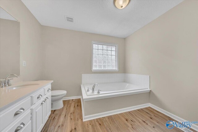 bathroom with vanity, visible vents, a bath, and wood finished floors