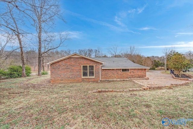 rear view of house featuring a yard, brick siding, and a patio