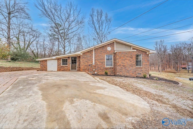 view of front facade with crawl space, concrete driveway, and brick siding
