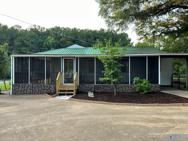 view of front of house featuring a sunroom and metal roof