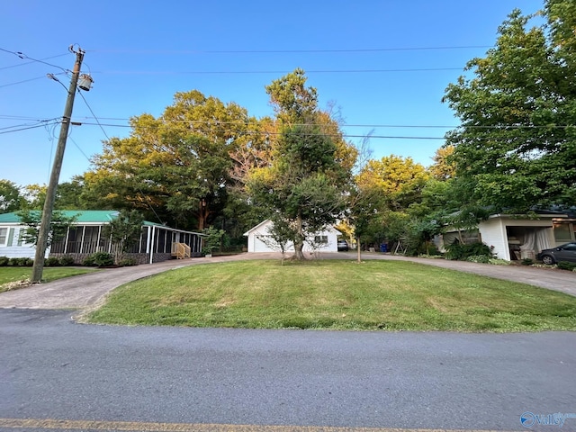 obstructed view of property with driveway and a front yard