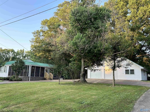 exterior space with a garage, a sunroom, and a front yard