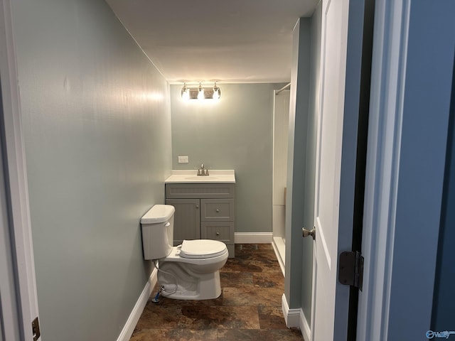 full bath featuring toilet, stone finish floor, baseboards, and vanity