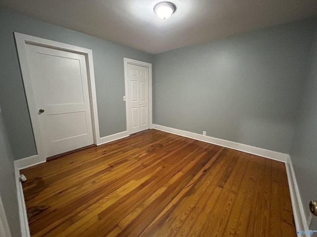 unfurnished bedroom featuring baseboards and wood finished floors