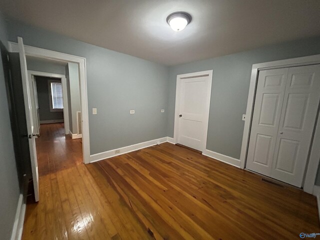 unfurnished bedroom featuring hardwood / wood-style flooring and a closet