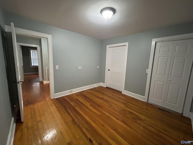 unfurnished bedroom featuring dark wood-style floors and baseboards