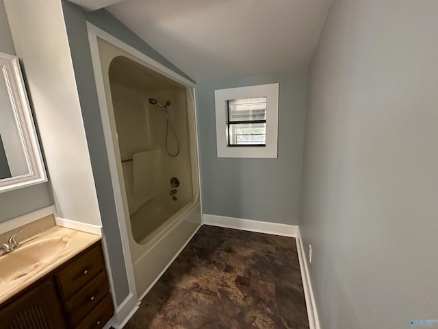 bathroom with vaulted ceiling, baseboards, tub / shower combination, and vanity