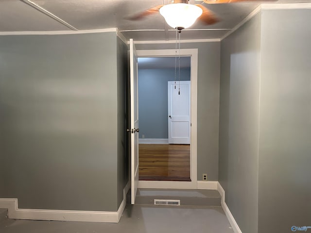 hall with ornamental molding, visible vents, finished concrete flooring, and baseboards