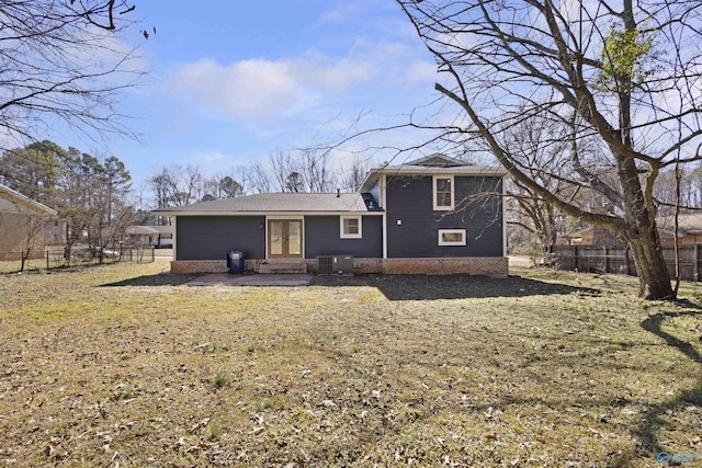 back of property with central AC unit and a lawn