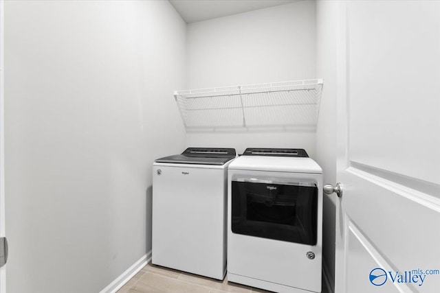 laundry area featuring washer and clothes dryer and light wood-type flooring