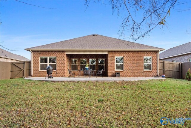 rear view of house featuring a patio area and a lawn