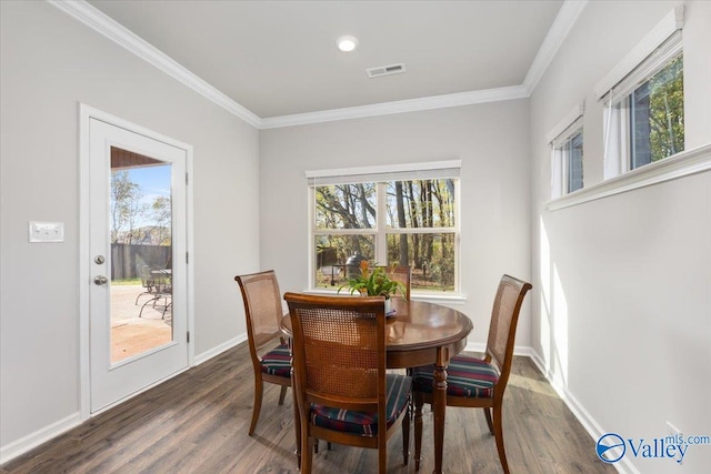 dining room with dark hardwood / wood-style floors, plenty of natural light, and crown molding