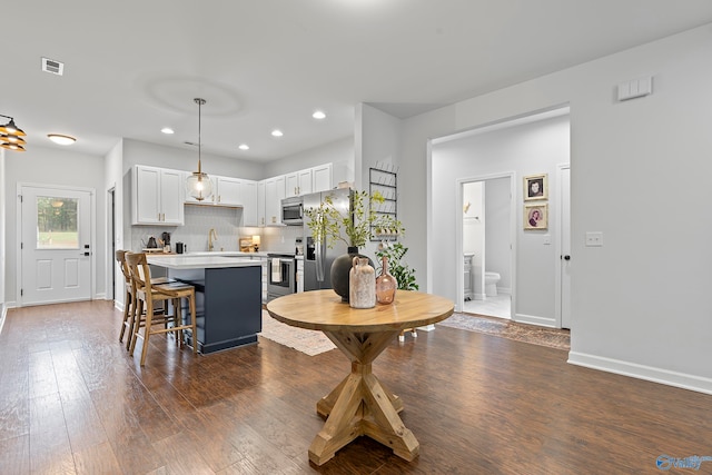 dining space with dark hardwood / wood-style floors and sink