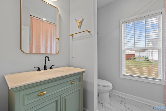 bathroom with plenty of natural light, vanity, and toilet