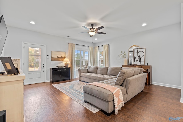 living room featuring dark wood-type flooring and ceiling fan