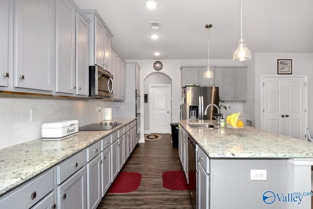 kitchen featuring visible vents, appliances with stainless steel finishes, a sink, and a center island with sink