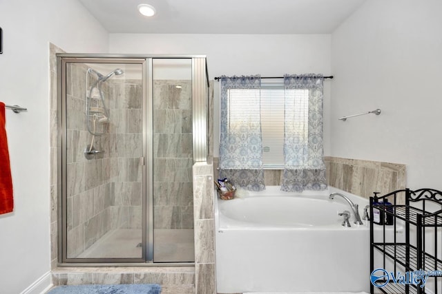 full bathroom with a shower stall and a bath